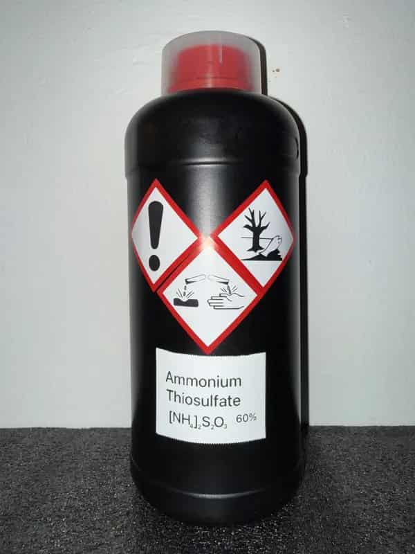 HDPE bottle of Ammonium Thiosulfate (60%) labeled with GHS icons: Corrosive, Irritant, Environmental